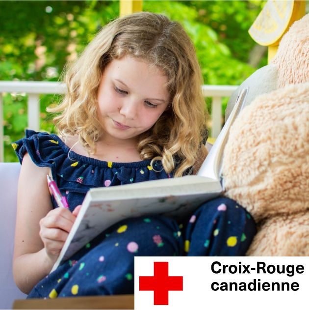 Jeune enfant écrivant dans un cahier avec un logo de la croix rouge